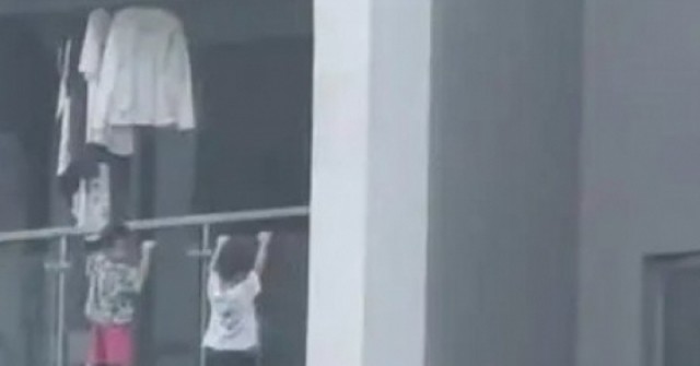 Thót tim cảnh 2 bé trai leo ra ngoài ban công tầng 13, làm động tác 'hít xà đơn'